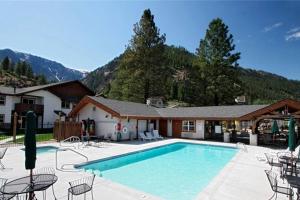 莱文沃思Aspen Suites 506: The Nest的一个带椅子的游泳池、一座房子和一座山脉