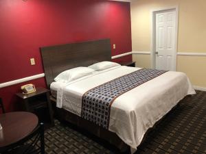 惠蒂尔惠蒂尔旅游旅馆的一间卧室设有一张红色墙壁的大床