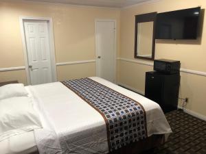 惠蒂尔惠蒂尔旅游旅馆的一间卧室配有一张床和一台平面电视