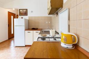 普莱克Sea view suite Mateo的厨房配有炉灶和白色冰箱。