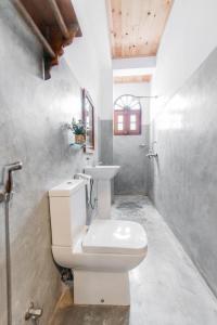 高尔Fort Sapphire的浴室配有白色卫生间和盥洗盆。