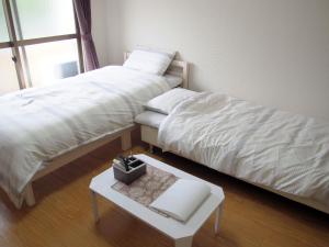 京都Free bike & free WIFI 301 Take it easy的一间卧室配有两张床和一张桌子及书籍