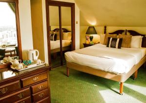 伦敦金丝雀码头不列颠国际大酒店的一间卧室配有一张床、梳妆台和镜子