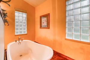 摩押Creekside Cowa-Bungalow!的浴室设有浴缸、橙色墙壁和窗户。