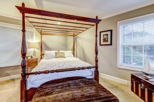博德加湾Bayside Cottage的一间卧室设有四柱床和两个窗户。