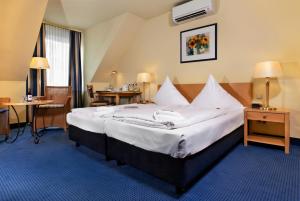 吕贝克海蓝宝石温德姆特里普酒店客房内的一张或多张床位