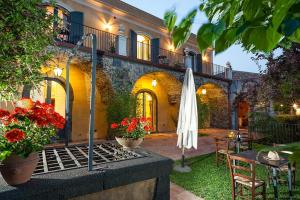 米罗Wine Resort Villagrande的户外庭院配有桌子和遮阳伞。