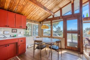 科帕利斯比奇Rocks Cabin的厨房配有红色橱柜和桌椅
