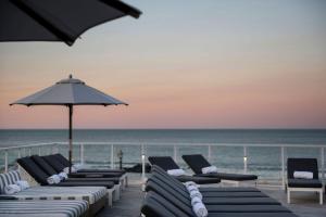 朗布兰奇Wave Resort的海滩上的一排躺椅和遮阳伞