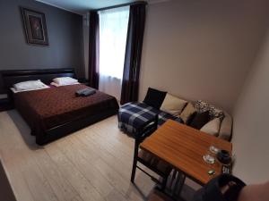 塔林Hotel Privat的一间卧室配有一张床、一张沙发和一张桌子