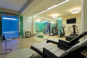 的里雅斯特里雅斯特萨瓦尔星际酒店的带沙发、椅子和镜子的健身房