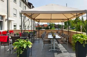 吕贝克吕贝克海蓝宝石温德姆特里普酒店的一个带桌椅的大伞下的露台