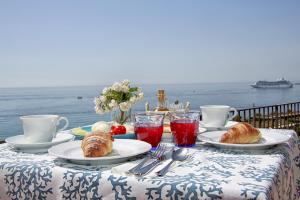 陶尔米纳斯特科佩塔住宿加早餐酒店的一张桌子,上面有羊角面包和糕点,上面有大海