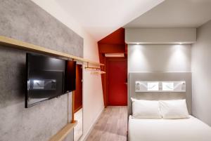 蒙彼利埃Ibis Budget Montpellier Nord Euromédecine的小房间设有一张床和一台平面电视