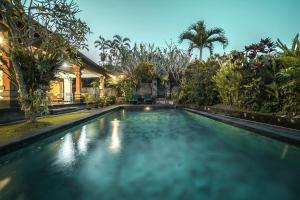 乌布尼尤曼桑迪旅馆的一座树木繁茂的房屋前的游泳池