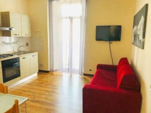 萨沃纳Violamare的一间带红色沙发的客厅和一间厨房