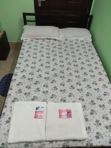 古瓦哈提Cozy Living的一张带黑白色棉被的床和两个枕头