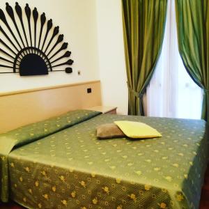 贝拉吉奥飞奥罗尼酒店的卧室配有一张绿色床,墙上设有镜子