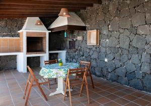 ConilApartamento Casa Belen的厨房配有一张桌子和椅子,厨房设有石墙
