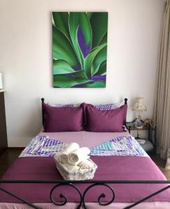 比亚拉Студио Панорама Сънрайз Бяла - кът за отдих и морска почивка的一间卧室配有一张紫色床,墙上挂有绘画作品
