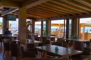 斯达林Socrates Hotel的餐厅设有桌椅和窗户。