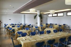 皮耶迪卢科米拉拉戈酒店的一间摆放着桌椅和蓝色椅子的房间