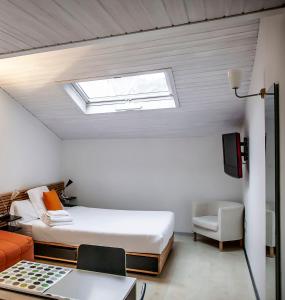 布尔戈斯玛丽亚莎乐美公寓式酒店的一间卧室配有一张床和天窗