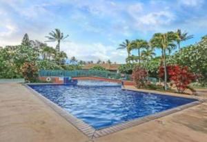 基黑KOA 3L的一座大蓝色的游泳池,在院子里种有棕榈树
