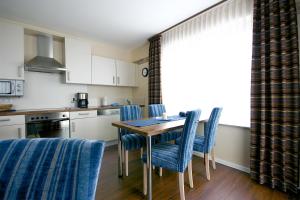 维林根Alm Appartements ehemals Birkenhof的厨房配有木桌和蓝色椅子