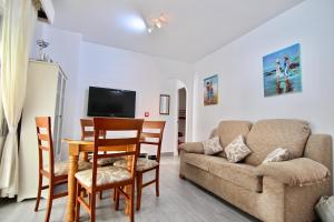 罗塔Apartamento Playa y Bosque的客厅配有沙发和桌子