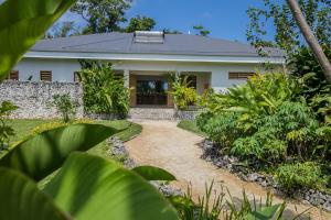 PangonaNakatumble - Luxury Sustainable Villa with Farm的房屋,有一条通往前门的通道