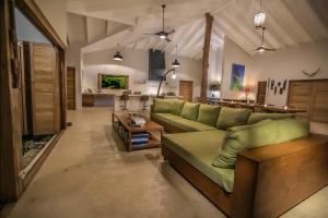 PangonaNakatumble - Luxury Sustainable Villa with Farm的客厅配有绿色沙发和桌子