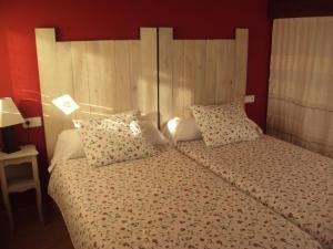 Quintueles罗斯奥贝托斯酒店的一间卧室配有一张带木制床头板和枕头的床。