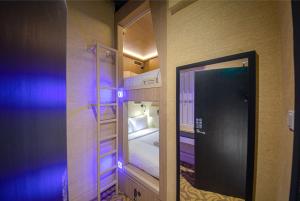 新加坡CUBE Boutique Capsule Hotel at Kampong Glam的一间小房间,配有双层床和镜子