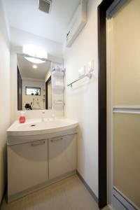 糸满EX Itoman Apartment 701的浴室设有白色水槽和镜子
