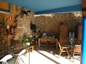 Ventosa拉斯哥达斯乡村旅馆的客厅设有石墙和桌椅