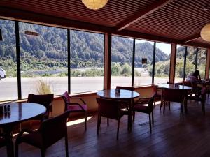 Newton FlatBerlins cafe, bar and backpackers的餐厅设有桌椅和大窗户。