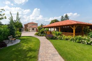 多瑙斯特雷达Villa Ephélia的一个带凉亭和砖砌走道的花园