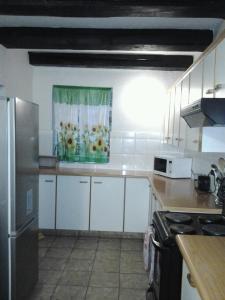 温特顿Ondini Guest House的厨房配有白色橱柜和鲜花窗户