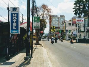 普禾加多Hotel Gunung Slamet的一群摩托车驶向城市街道,带有标志
