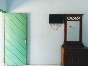 普禾加多Hotel Gunung Slamet的一间设有绿门和镜子的客房