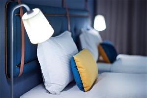 台北捷丝旅西门町馆的客房配有两张带枕头和灯的床。