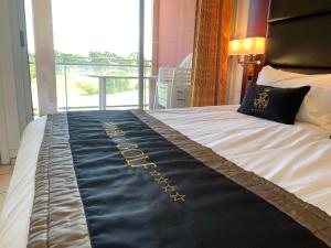 安格雷滨海高尔夫公寓式酒店的床上有黑色和金色的毯子