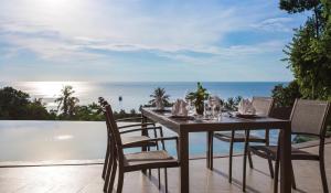 查汶Eranda Pool Spa Villa, Chaweng Koh Samui- SHA Extra Plus的海景露台上的餐桌和椅子