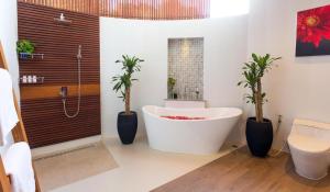 查汶Eranda Pool Spa Villa, Chaweng Koh Samui- SHA Extra Plus的带浴缸和2种盆栽植物的浴室