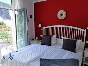 格洛韦Ferienwohnung SteinReich的卧室配有白色的床和红色的墙壁