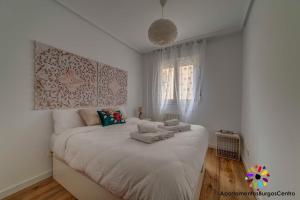 布尔戈斯Edificio Aptos Turisticos - Burgos Centro HC7的白色卧室配有一张大床和毛巾