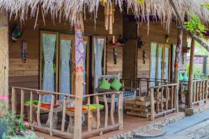 珀尼达岛Pondok Kana And Hostel by Ecommerceloka的一个带椅子和门廊的度假村,