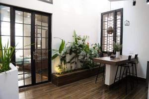 岘港Chaca House的一间设有盆栽植物的房间和一张桌子