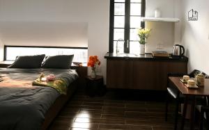 岘港Chaca House的一间卧室配有一张床、一张书桌和一个窗户。